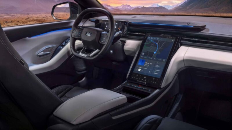 Şehir içinde ilerleyen beyaz renkli 2026 model Ford Explorer elektrikli SUV